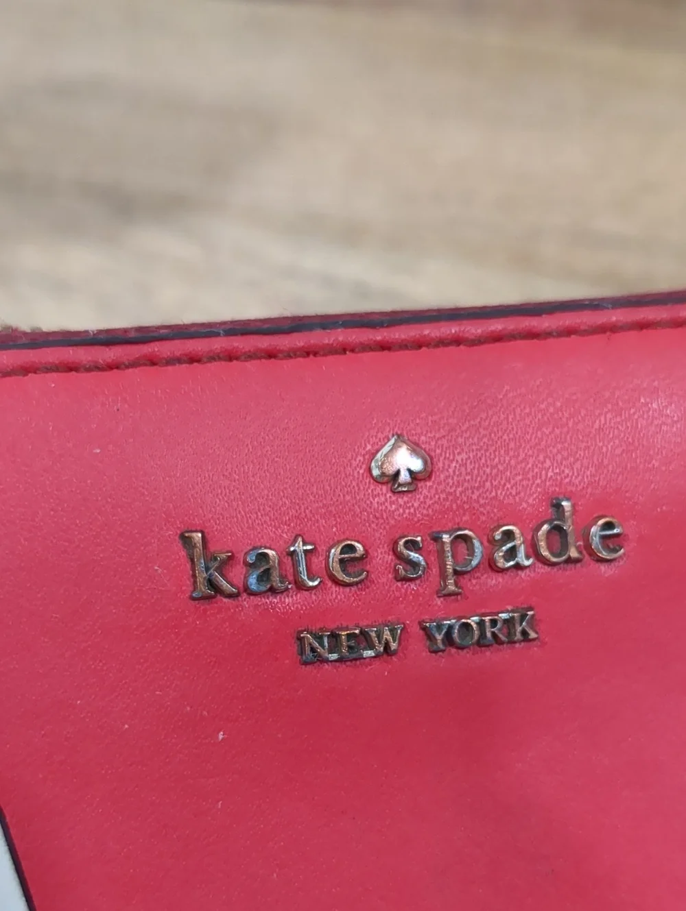 Kate Spade red zip-around wallet with Ace of Spades patch